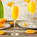 Mimosas with orange slices on table